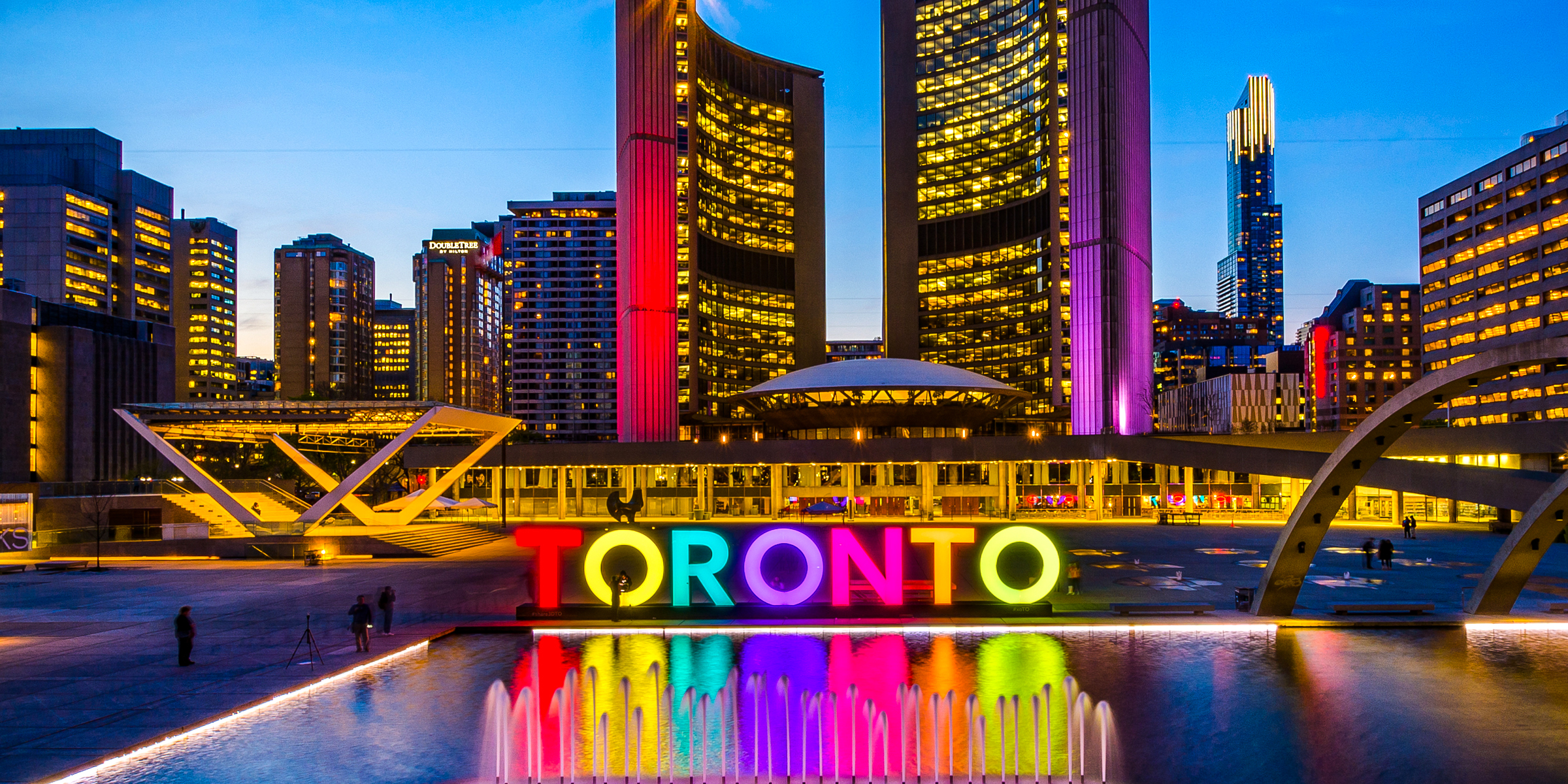 The Toronto Sign lights up downtown Toronto at twilight. | Source: Shutterstock