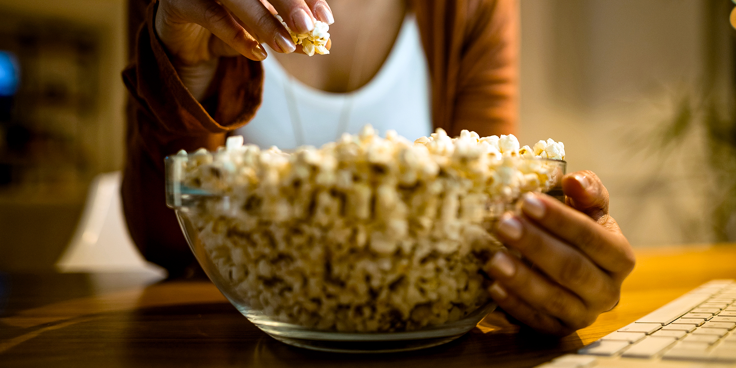A woman eating a bowl of popcorn | Shutterstock