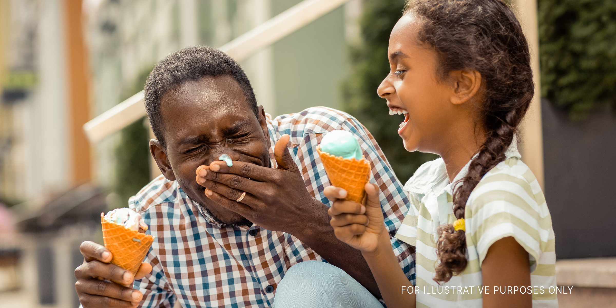 A parent and child eating ice cream and laughing | Source: Getty Images