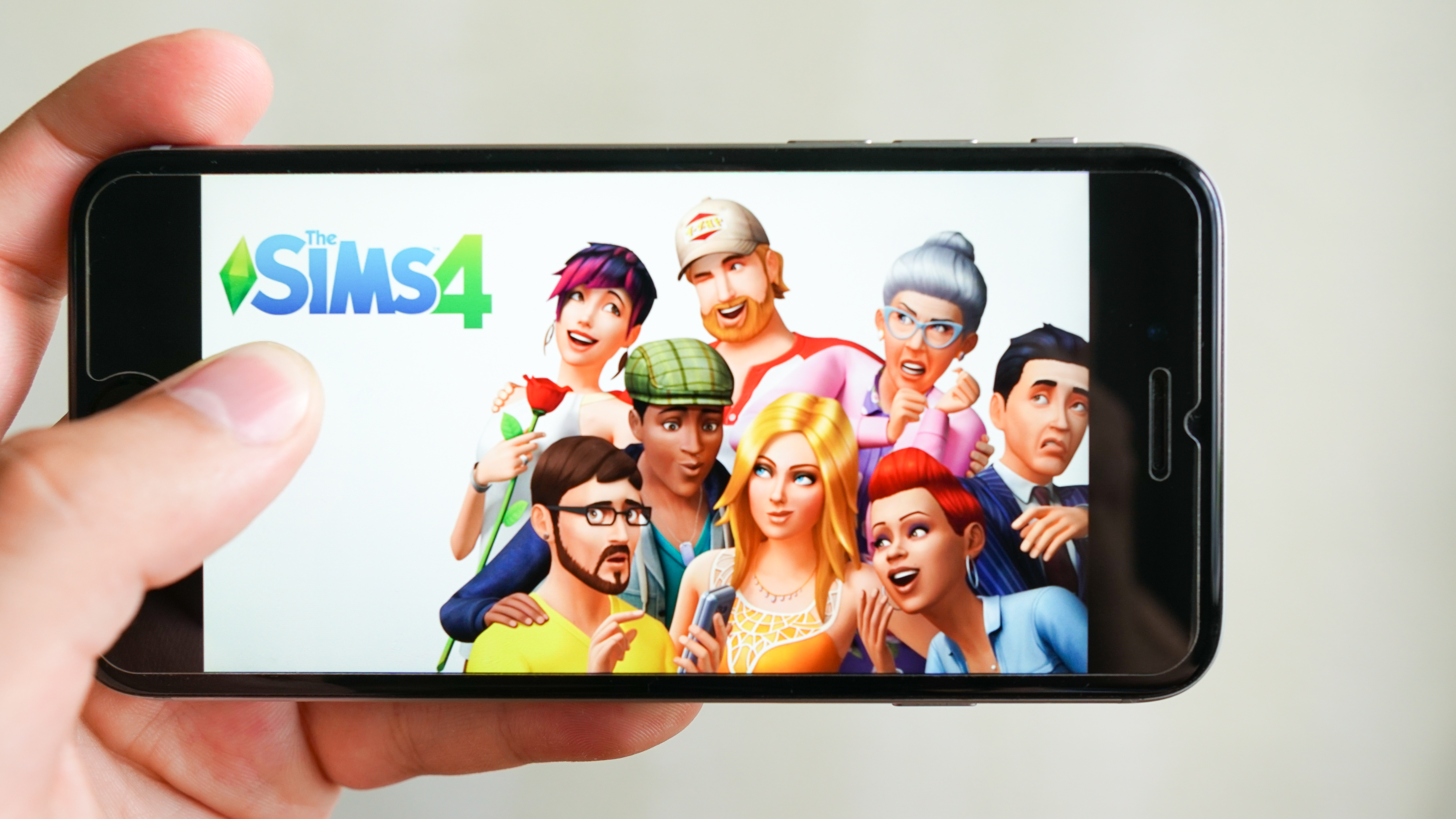 "The Sims 4" poster displaying on a touch screen smartphone | Source: Shutterstock
