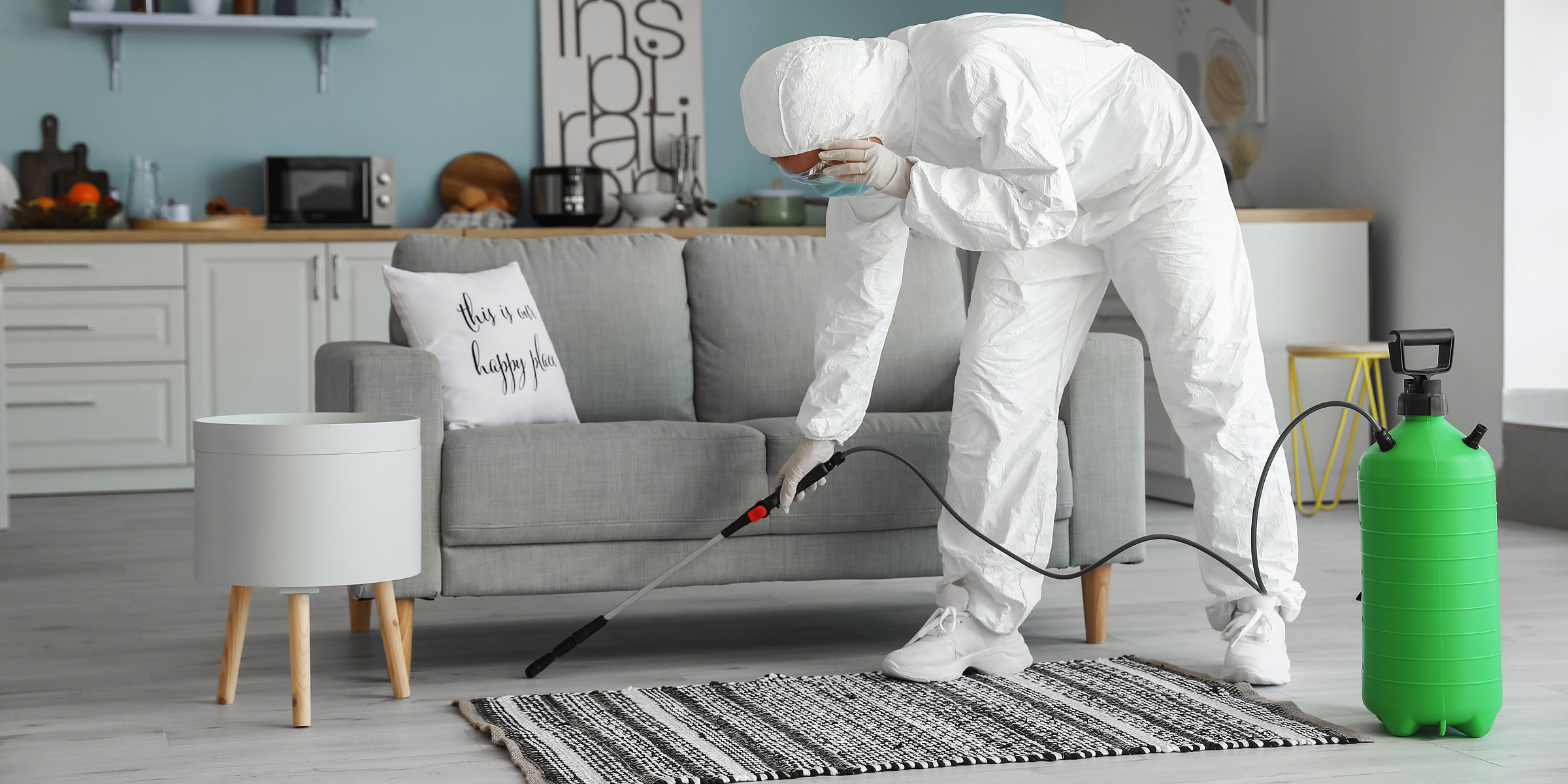 A person in protective gear fumigating a living room | Source: Shutterstock