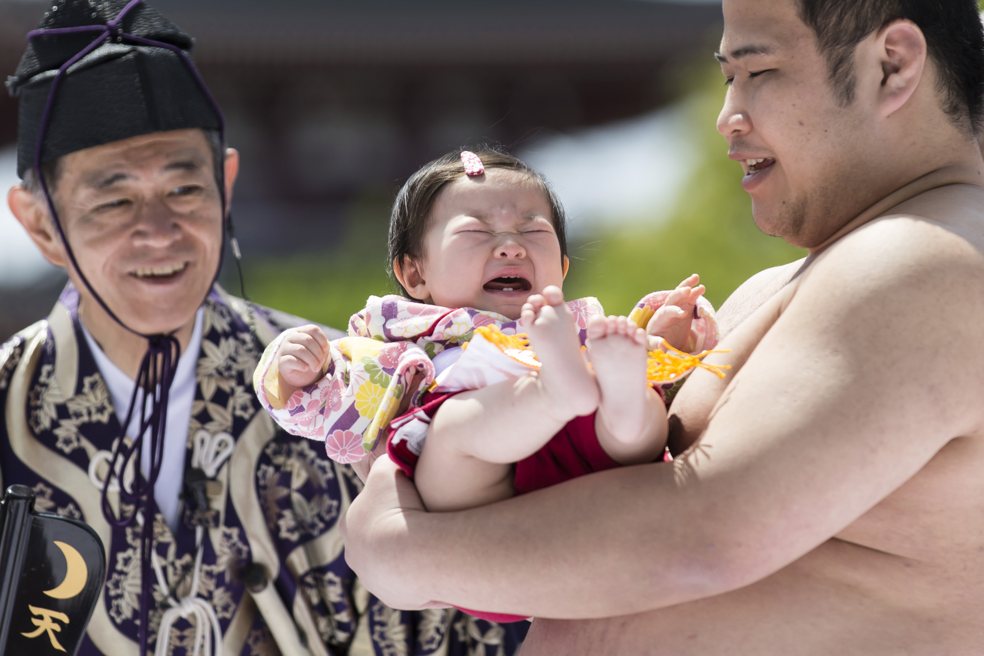 A baby, held by a sumo wrestler, cries during the Nakizumo or Naki Sumo Baby Crying contest at Sensoji Temple on April 28, 2019, in Tokyo, Japan. | Source: Getty Images